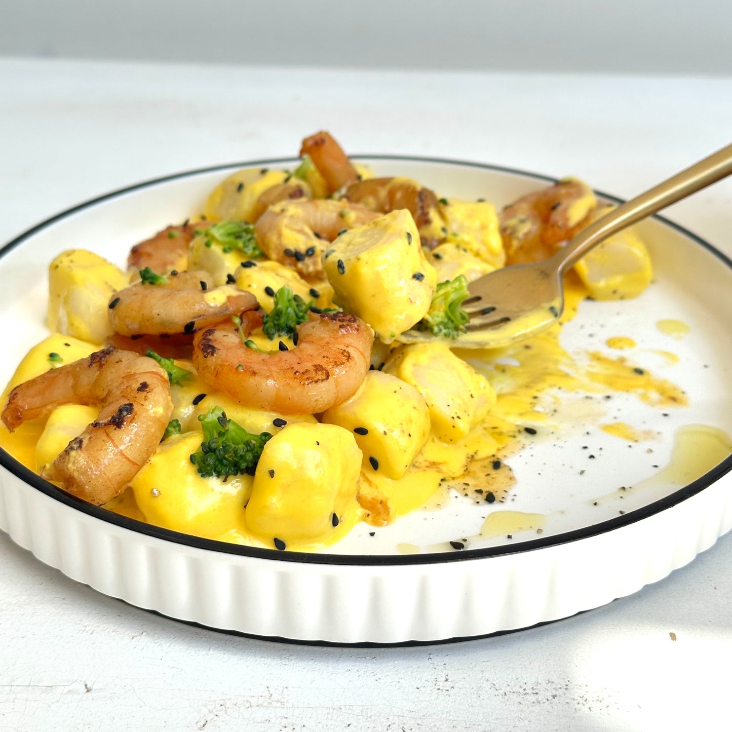 Ñoquis con salsa huancaína y camarones salteados en mandarina