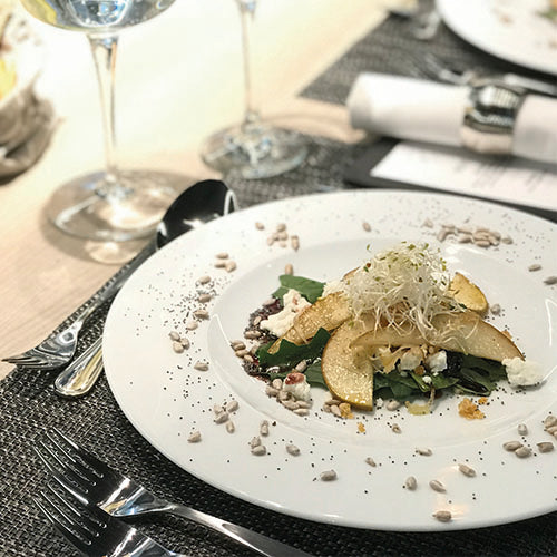 Ensalada de espinacas baby con peras y chalotas asadas, nueces acarameladas , queso de cabra y vinagreta de moras