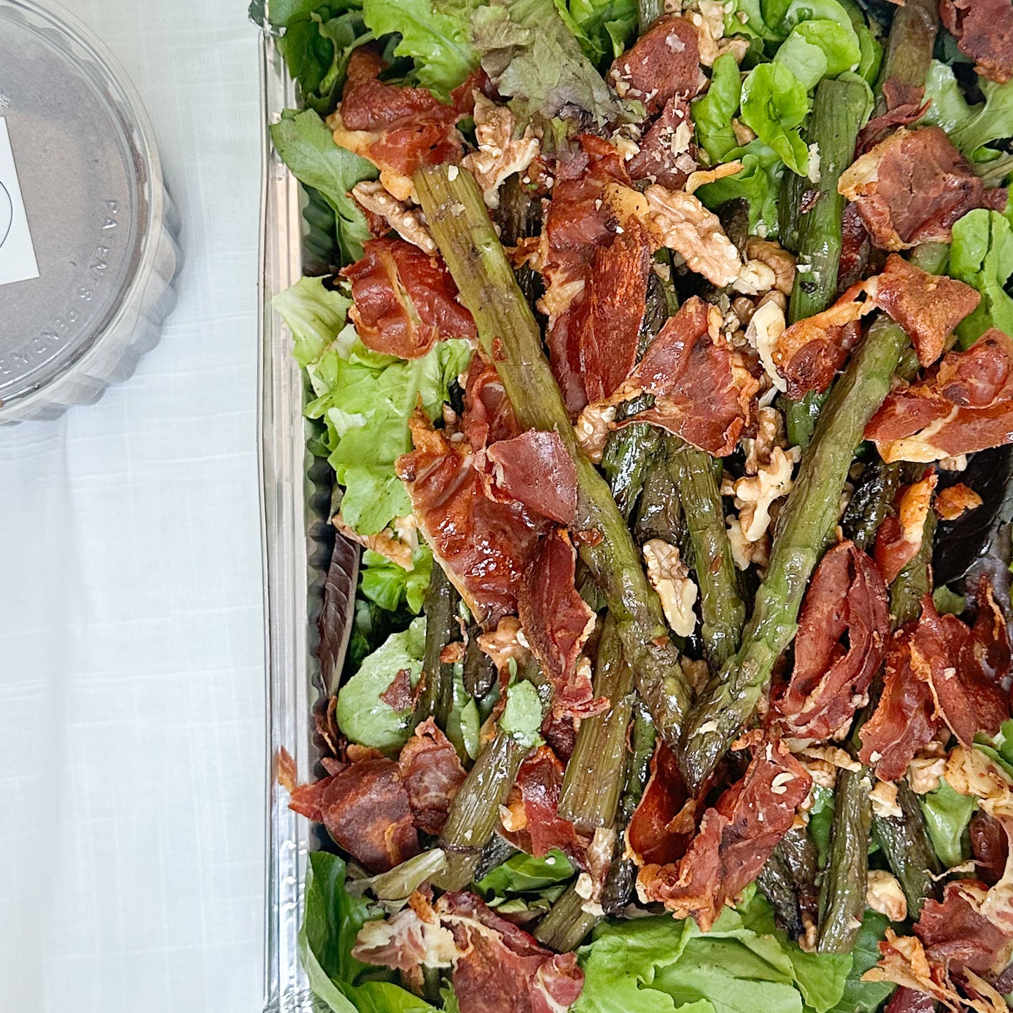 Ensalada verde con espárragos salteados, jamón serrano crocante, nueces acarameladas y aliño de moras y oporto