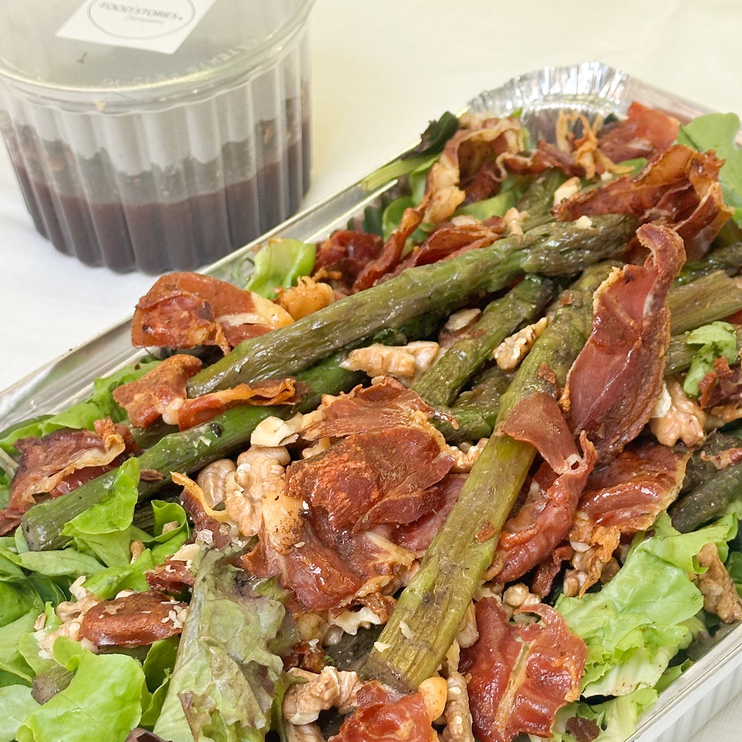 Ensalada verde con espárragos salteados, jamón serrano crocante, nueces acarameladas y aliño de moras y oporto