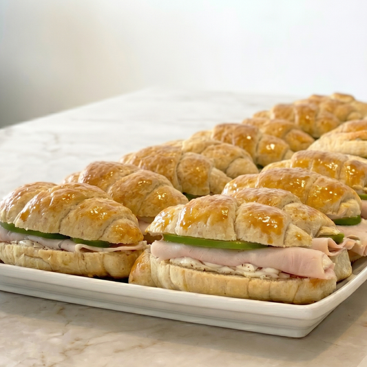 Sandwich en pan de hoja con jamón de pavo, queso crema y manzanas salteadas