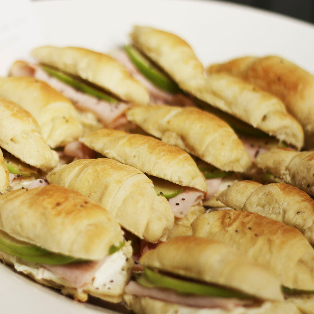 Sandwich en pan de hoja con jamón de pavo, queso crema y manzanas salteadas